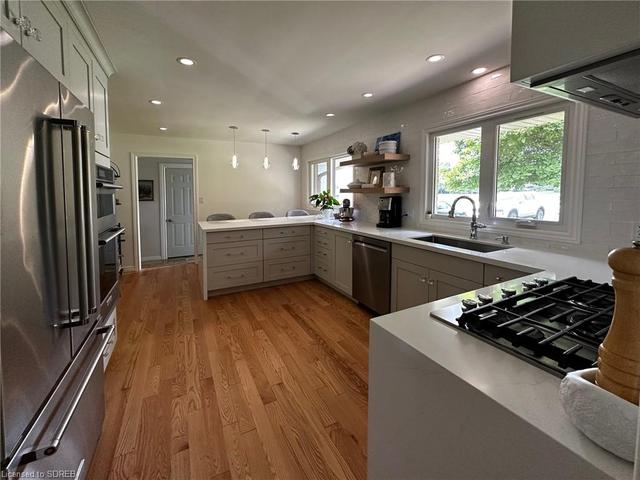 Kitchen - Professionally designed and renovated (2020)Thick quartz countertop. undermount deep sink, Stainless appliances including countertop gas stove, built in oven, built in microwave, potfiller, hardwood floors, open to dining room. | Image 5