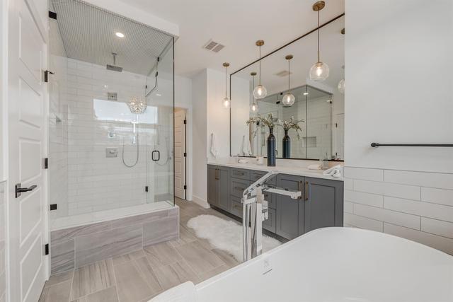 The primary bedroom detailed with tray ceiling and complete with a walk-in closet and spa-inspired ensuite with soaker tub, dual vanity and rainfall showerhead | Image 16