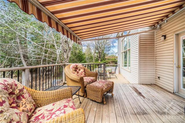 The 2-tier cedar deck has a retractable awning, BBQ and outdoor dining area and just steps down to a luxurious and relaxing hot tub! | Image 27