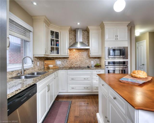 A builders show home, showcasing granite counter tops, custom tile backsplash and a wall mount chimney rangehood! | Image 8