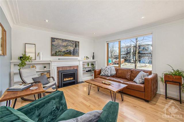 The formal living room has been updated with a gas fireplace but has maintained charm with original built-ins | Image 4