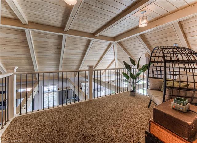 Upstairs, an inviting den overlooks the main living area | Image 13