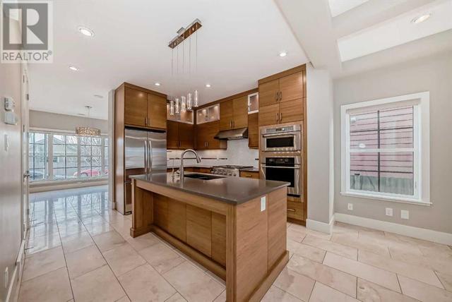 The chef's kitchen is a standout feature, with its high-end stainless steel appliances, custom cabinets, and quartz island | Image 3
