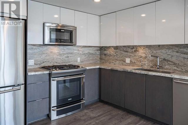 Open concept with granite, backsplash and upgraded appliances including gas stove | Image 3