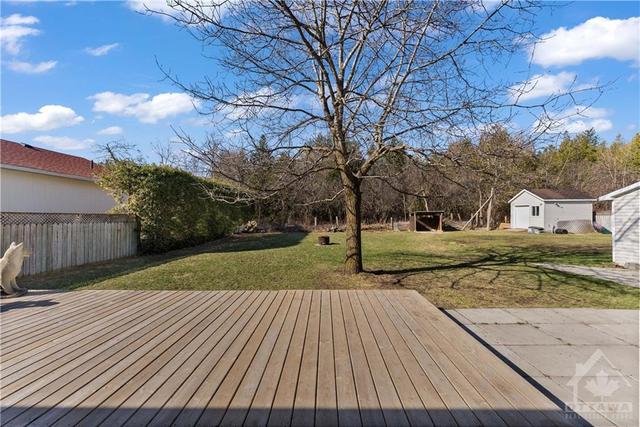 Extra large deck to sit out and relax on those hot summer days.  Backing onto wooded area. | Image 25