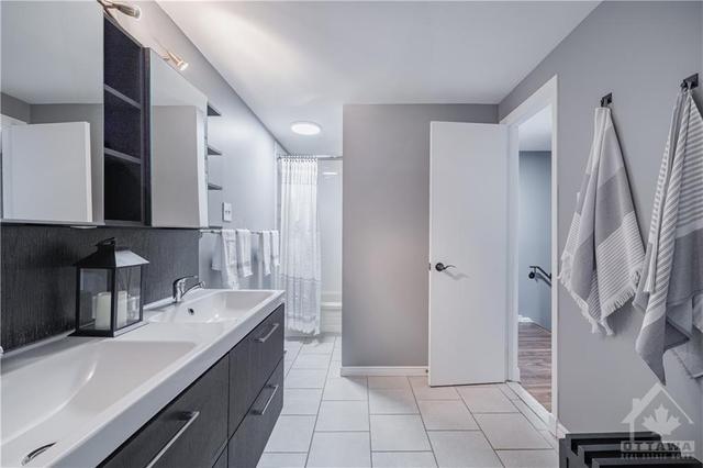 This fabulous cheater en-suite is well designed and boasts an updated vanity and with double sinks. | Image 18