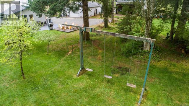 oLandscaped backyard with fruit trees, a swing set, monkey bars, tetherball, playhouse with slide, sandbox and zip line. | Image 77