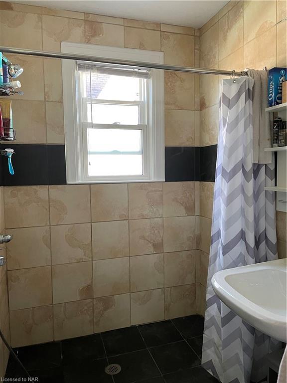 Main floor roll or walk-in large tiled shower, wheelchair accessible. | Image 20