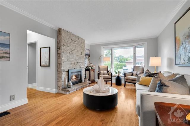 Impeccably maintained by the original owners, with plenty of natural light. The living room is spacious with a cozy fireplace. | Image 6