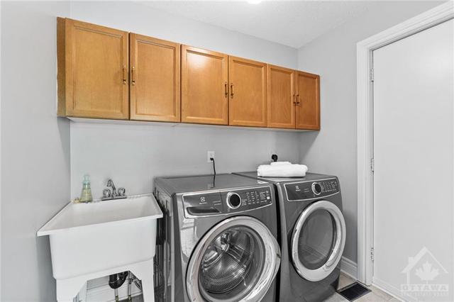 Laundry room w/ sink, storage above, double closet & inside access to garage. | Image 15