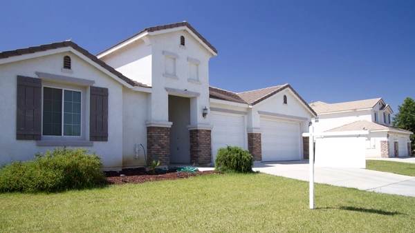 A house with a for sale sign on the front yard.