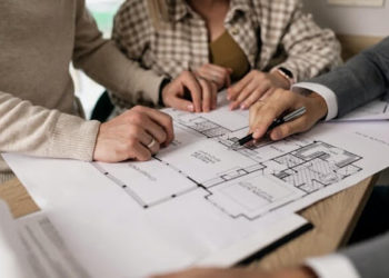 real estate brokerage reviewing house blueprints to potential buyers