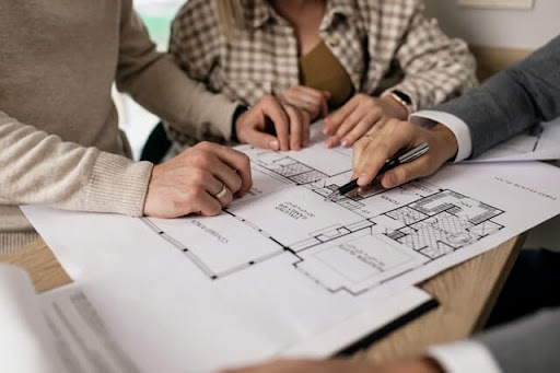 real estate brokerage reviewing house blueprints to potential buyers