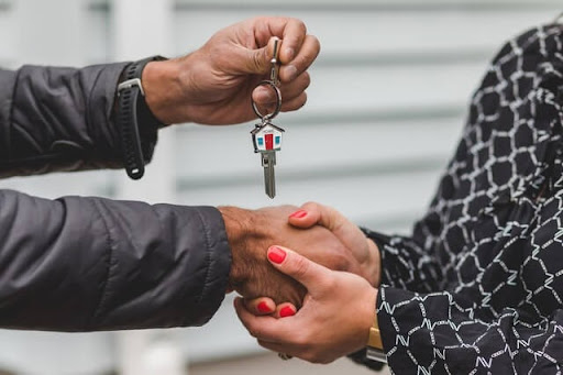 A real estate agent handing over keys to a new homeowner
