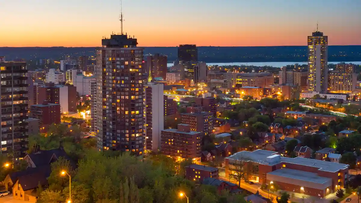 A city skyline at dusk, featuring silhouetted buildings against a colorful twilight sky.