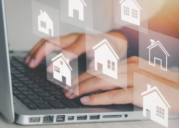 Someone typing on a computer with home icons surrounding the keyboard.