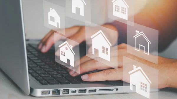 Someone typing on a computer with home icons surrounding the keyboard.