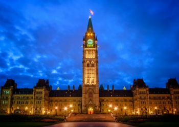 New Federal Housing Initiatives to Watch for in 2023 Blog Hero. A photo of the parliament building with the lights on during a cloudy night.