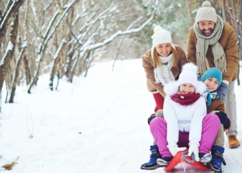 A family sledding in the snow