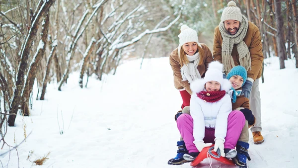 A family sledding in the snow