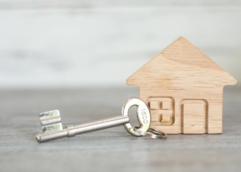 A small wooden house with a key next to it.