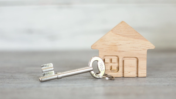 A small wooden house with a key next to it.