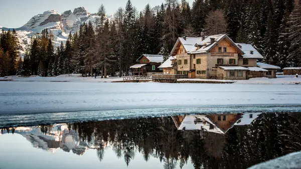 A large snowcovered home on a lake