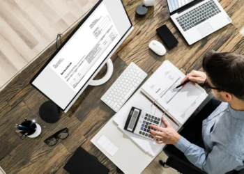 A person sits at a desk doing their taxes.