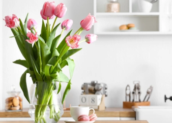 Flowers in a vase on a kitchen counter.