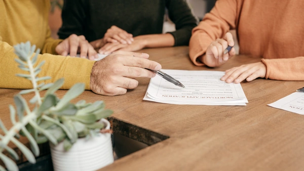 A group of people looking at a mortgage application form.