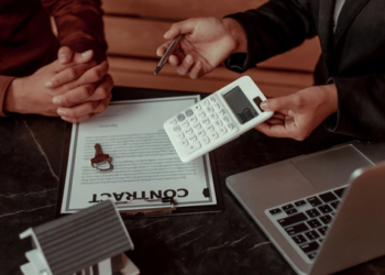 Two people doing calculations for a mortgage with a calculator