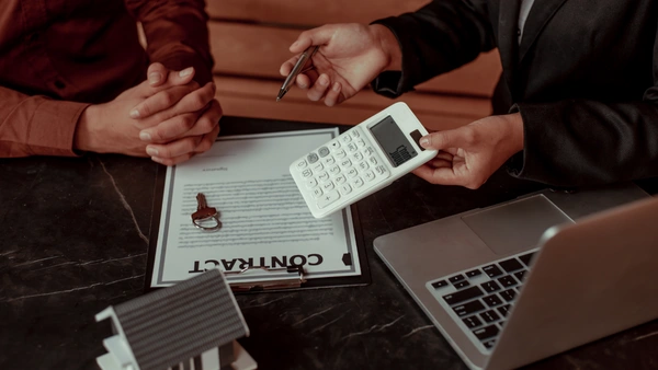 Two people doing calculations for a mortgage with a calculator