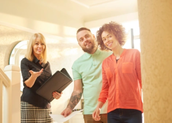 A real estate agent shows a couple a house