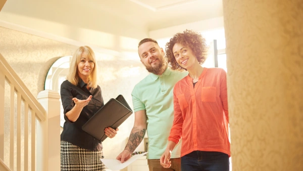 A real estate agent shows a couple a house