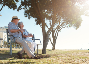 An older couple sitting on a bench.