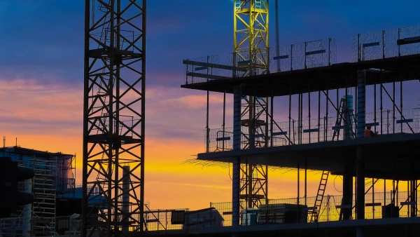 A pre-construction building with a sunset behind it