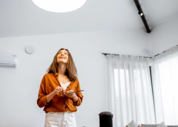 A woman looks up at a light in her home