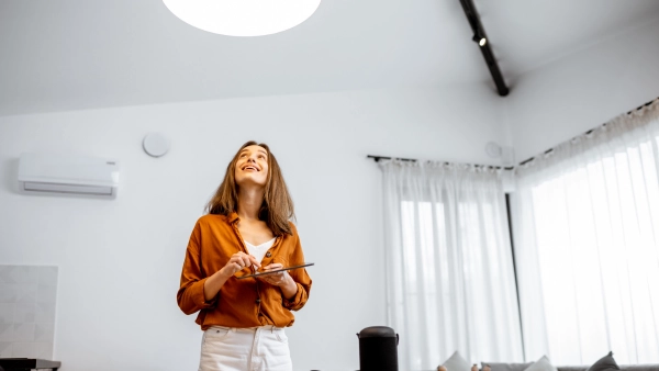 A woman looks up at a light in her home