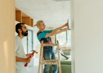 A couple paints a wall