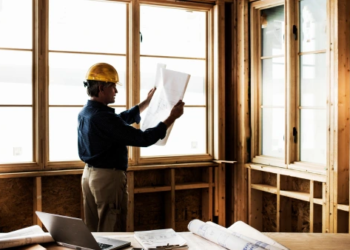 Construction workers looks at building plans.