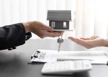 Two hands give a small house and keys to another pair of hands