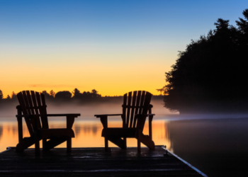 Two chairs overlooking a lake.