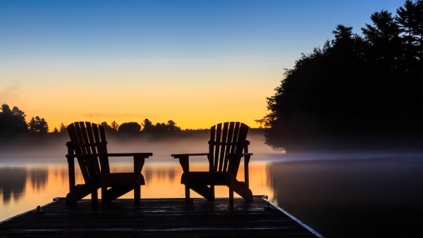 Two chairs overlooking a lake.