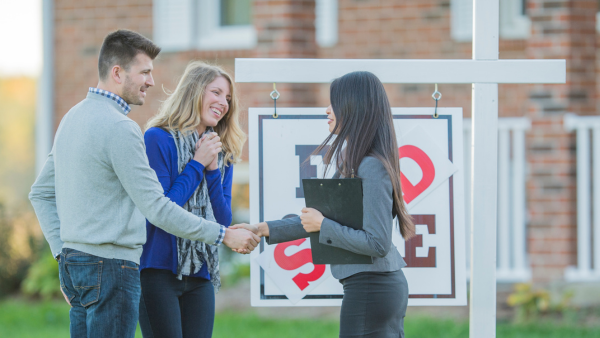 Homebuyers shaking hands with realtors.