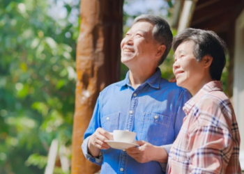 A retired couple outside smiling