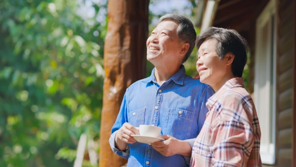 A retired couple outside smiling