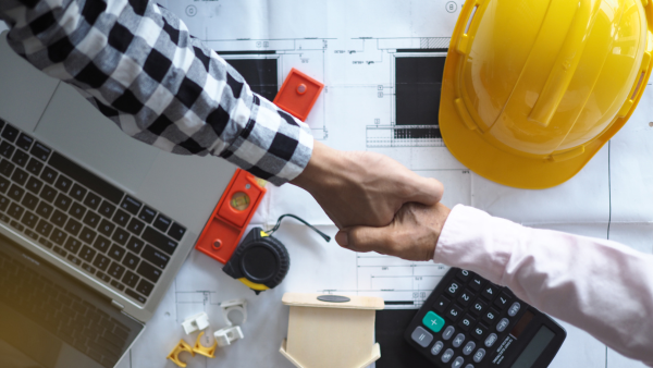 A builder and a homeowner shaking hands.