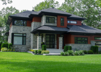 A red brick home on a grassy lawn.