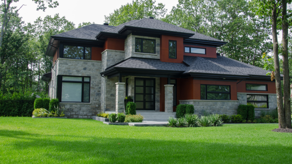 A red brick home on a grassy lawn.