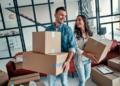 A couple holding several moving boxes